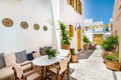 a patio with a table and chairs and plants at Villa il Vecchio Cortile in Rhodes Town