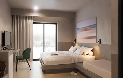 a bedroom with a bed and a desk and a television at Olive Garden Hotel in Lardos