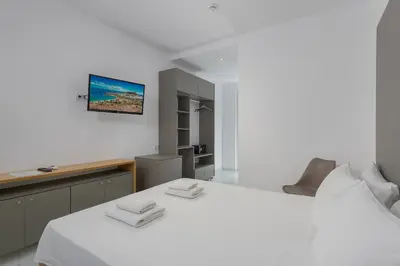 a bedroom with a white bed with two towels at Olive Garden Hotel in Lardos