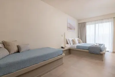 a bedroom with two beds and a window at Olive Garden Hotel in Lardos