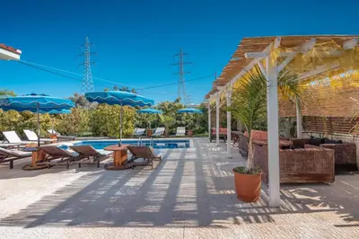 a pool with chairs and umbrellas next to a building at Artzy Villa in Rhodes Town