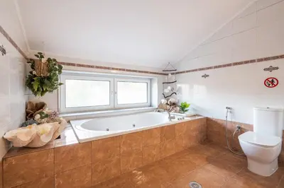 a large bathroom with a tub and a toilet at Artzy Villa in Rhodes Town