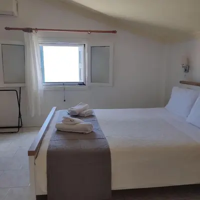 a bedroom with a large bed with towels on it at Anastasia Hotel in Symi
