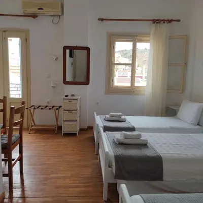 a bedroom with two beds and a mirror at Anastasia Hotel in Symi