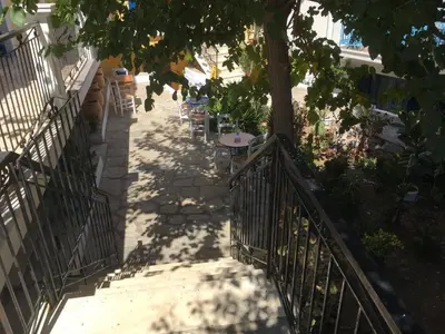 a staircase with a tree and a table and chairs at Anastasia Hotel in Symi