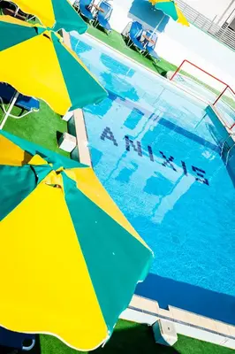 a group of umbrellas sitting next to a swimming pool at Anixis Hotel & Apartments in Ialyssos