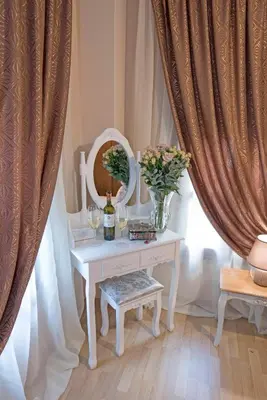 a table with a vase of flowers and a mirror at Athina house in Rhodes Town