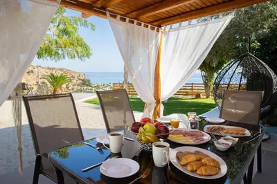a table with food on it with a view of the ocean at Blue View Stegna House in Archangelos