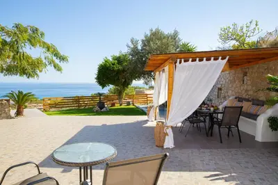 a patio with a tent and a table and chairs at Blue View Stegna House in Archangelos