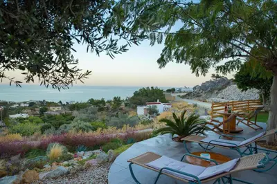 a patio with chairs and a view of the ocean at Blue View Stegna House in Archangelos