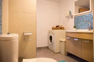 a bathroom with a washing machine and a sink at Blue View Stegna House in Archangelos