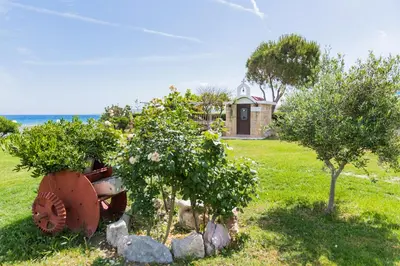 a tractor in a field with two trees and a house at Nastazia Luxury Beach House in Ialyssos