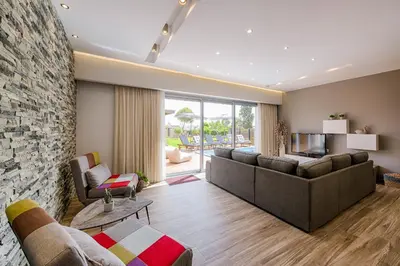 a living room with couches and a stone wall at Nastazia Luxury Beach House in Ialyssos