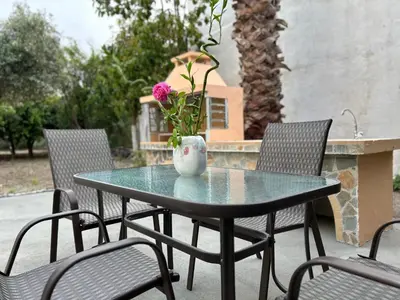 a table with chairs and a vase with flowers on it at Lina's Amazing House in Ialysos in Ixia