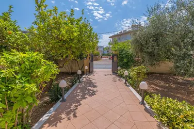 a walkway through a garden with trees and bushes at Lina's Amazing House in Ialysos in Ixia