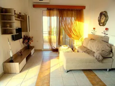 a living room with a couch and a large window at Cozy apartment in Paradisi in Paradeísion