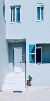 a white building with a white door and stairs at Retas apartment up in Kremasti