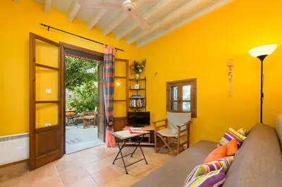 a living room with yellow walls and a couch at Serene House,Beautiful Garden in Old Town in Rhodes Town