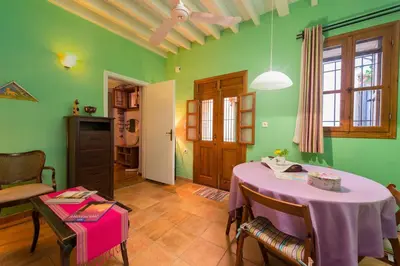 a dining room with a table and a room with green walls at Serene House,Beautiful Garden in Old Town in Rhodes Town