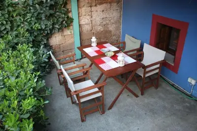a wooden table and chairs on a patio at Serene House,Beautiful Garden in Old Town in Rhodes Town