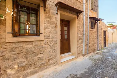 a stone building with a window on a street at Serene House,Beautiful Garden in Old Town in Rhodes Town