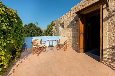 a patio with a table and chairs on it at Serene House,Beautiful Garden in Old Town in Rhodes Town