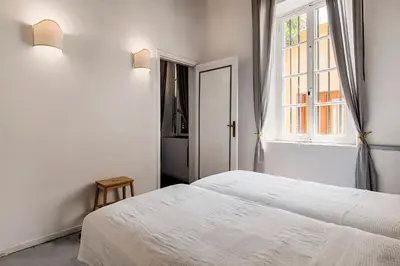 a white bedroom with a bed and a window at Casa Elettra in Rhodes Town