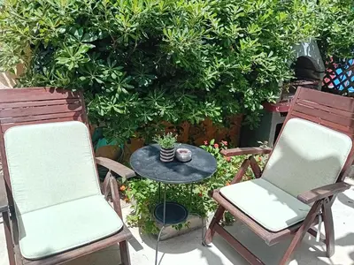two chairs and a table in front of a bush at Old Town House with Garden, Fully Equipped & Peaceful in Rhodes Town