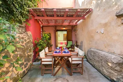 a patio with a table with chairs and an umbrella at Old Town House with Garden, Fully Equipped & Peaceful in Rhodes Town