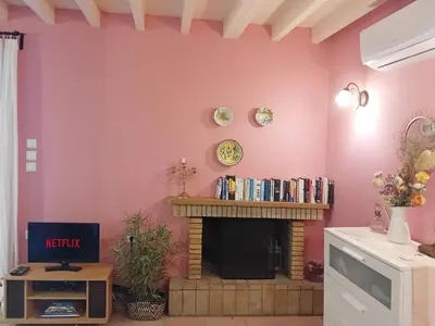 a living room with a pink wall with a fireplace at Old Town House with Garden, Fully Equipped & Peaceful in Rhodes Town