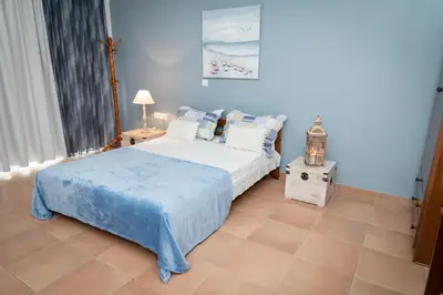 a bedroom with a bed and a lamp on a tiled floor at PANOS APARTMENTS in Archangelos