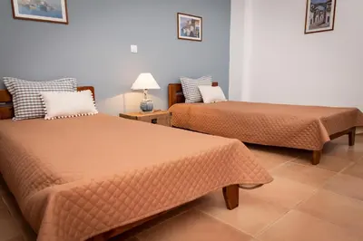 two beds sitting next to each other in a room at PANOS APARTMENTS in Archangelos