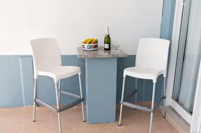 two white bar stools in a kitchen with a counter at PANOS APARTMENTS in Archangelos