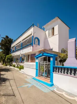 a white and blue building with a gate at Poseidon Apartment in Archangelos