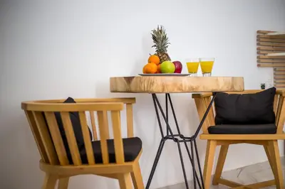 a table with a bowl of fruit and two glasses of orange juice at Ammos Luxury Suites in Faliraki