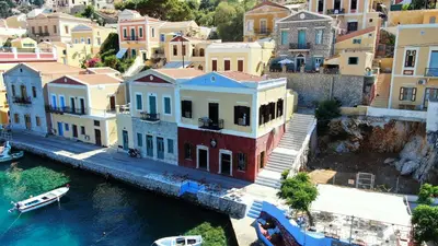 a group of houses next to a body of water at Moschos Mansion in Symi