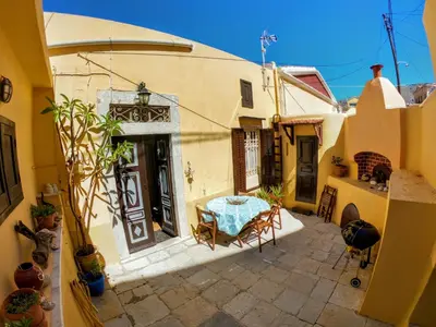 an outdoor patio with a table in a house at Moschos Mansion in Symi