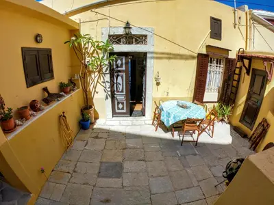 an outdoor patio with a table and chairs in a building at Moschos Mansion in Symi
