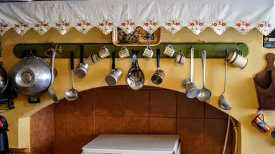 a bunch of utensils hanging on a wall in a kitchen at Moschos Mansion in Symi