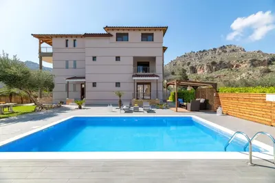 a villa with a swimming pool in front of a house at Costa Costa Villa - Luxury villa in Kolimbia