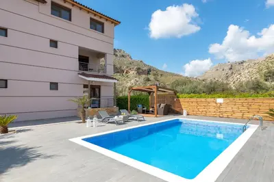 a swimming pool in front of a house at Costa Costa Villa - Luxury villa in Kolimbia