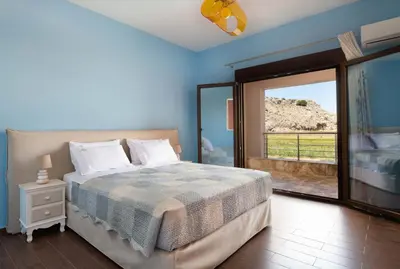 a bedroom with a bed and a sliding glass door at Costa Costa Villa - Luxury villa in Kolimbia