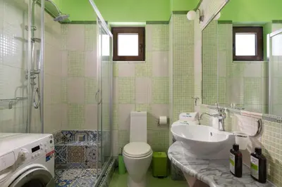 a bathroom with a toilet and a sink and a washing machine at Costa Costa Villa - Luxury villa in Kolimbia
