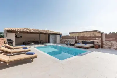 a patio with a swimming pool and a house at M & S Villa - 4 bedroom villa with heated pool in Pastida