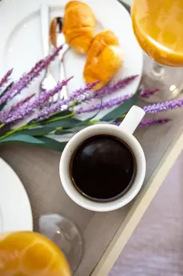 a cup of coffee and a plate of food and flowers at M & S Villa - 4 bedroom villa with heated pool in Pastida