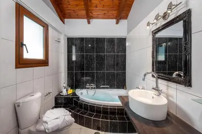 a bathroom with a tub and a sink and a toilet at Luxury Mansion Rhodes in Ialyssos