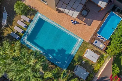 an overhead view of a swimming pool with palm trees at Luxury Mansion Rhodes in Ialyssos