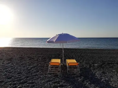 two chairs and an umbrella on the beach at Cedrus and Sea, beachfront house, Gennadi, Rhodes in Gennadi