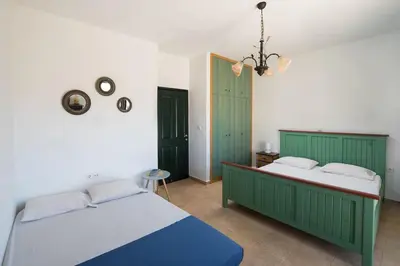 two beds in a bedroom with green and white at Cedrus and Sea, beachfront house, Gennadi, Rhodes in Gennadi