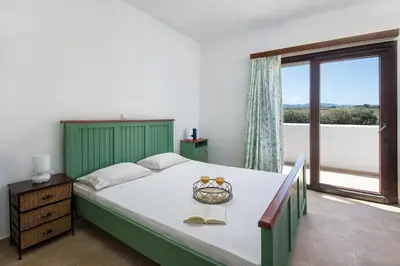 a bedroom with a large bed and a large window at Cedrus and Sea, beachfront house, Gennadi, Rhodes in Gennadi